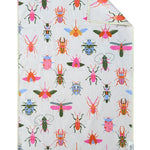 A hand towel with a multicolored pattern featuring various bees and ladybugs on a light background.