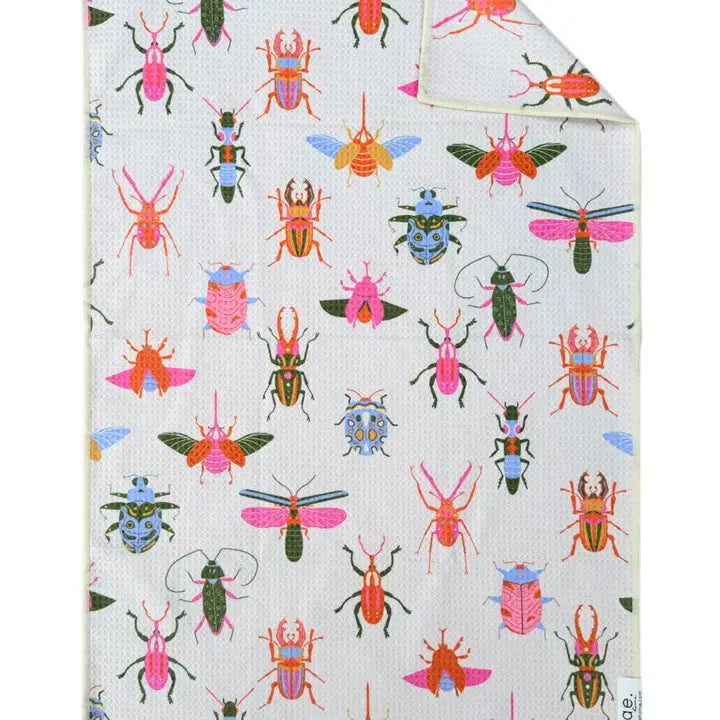 A hand towel with a multicolored pattern featuring various bees and ladybugs on a light background.