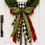 Bow of black and white harlequin, olive green and red velvet ribbons with gold edges on a boxwood wreath