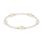 Stretch bracelet with alternating white pearls and small gold beads