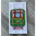 White towel printed with a green NOLA streetcar decorated with a Christmas wreath and garland
