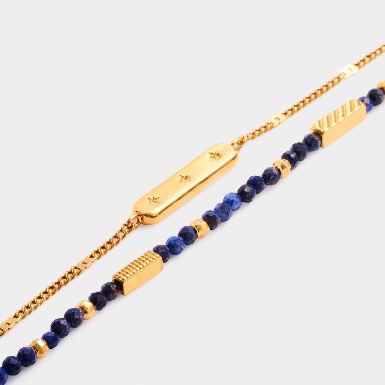 Gold chain bracelet with star engraved bar and beaded lapis lazuli bracelet with gold accents