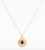 Gold chain necklace with a round pendant and black stone
