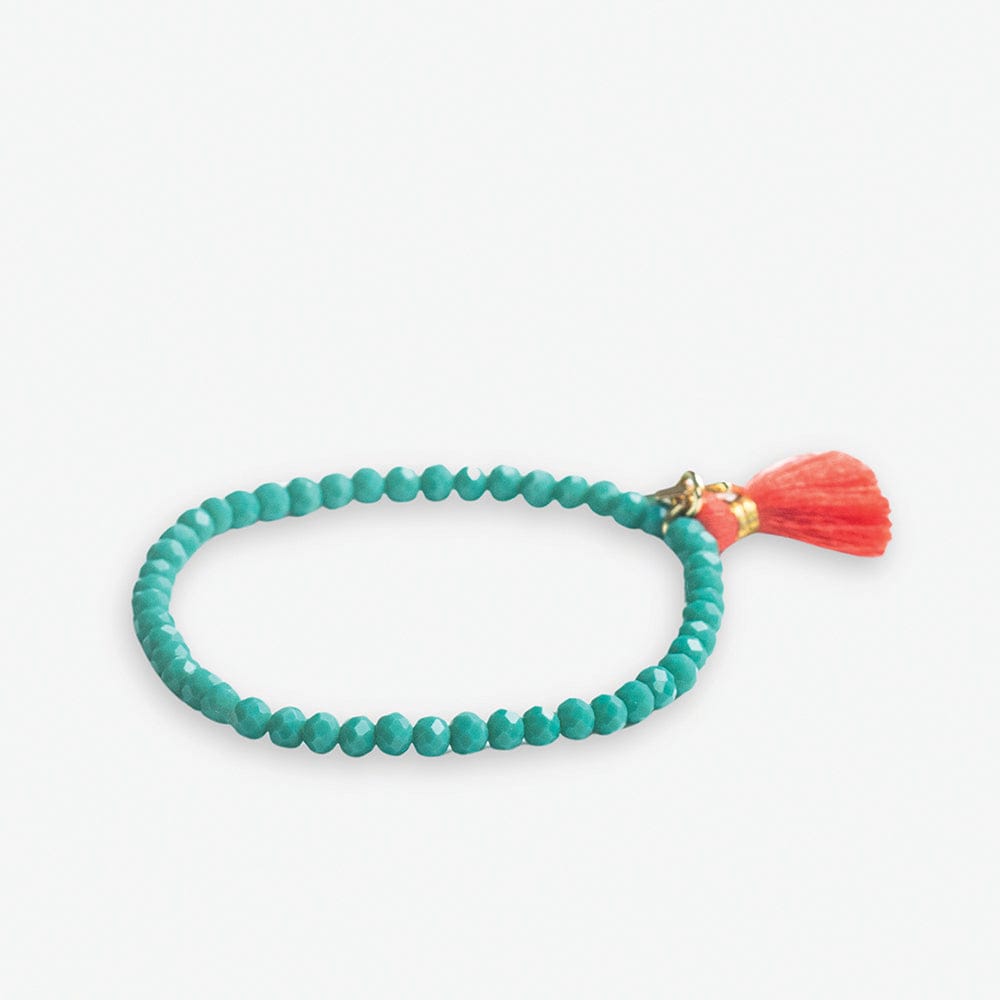 Faceted turquoise beaded bracelet featuring a vibrant coral tassel and a delicate gold-toned clasp