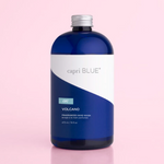 A blue bottle labeled 'capri BLUE volcano hand wash refill' on a pink background.