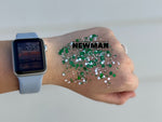 Photograph of a person's hand wearing a light blue Apple Watch displaying 10:53 and covered in bright green and white hexagonal glitter with the word NEWMAN superimposed