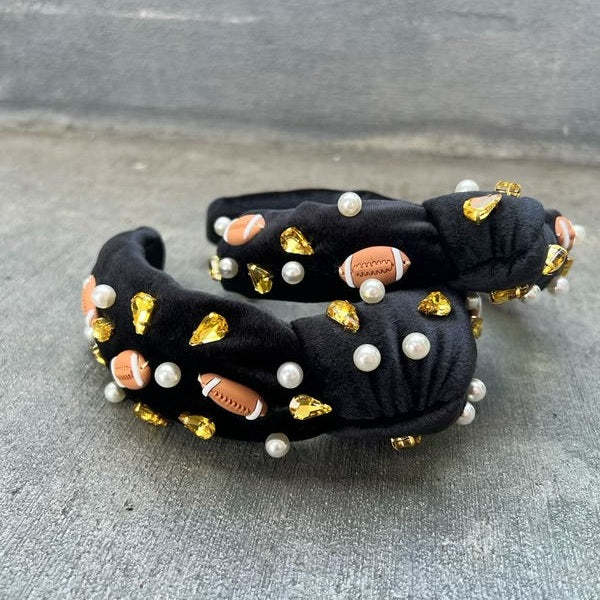 A black headband with a football design, featuring gold-colored beads and pearls.