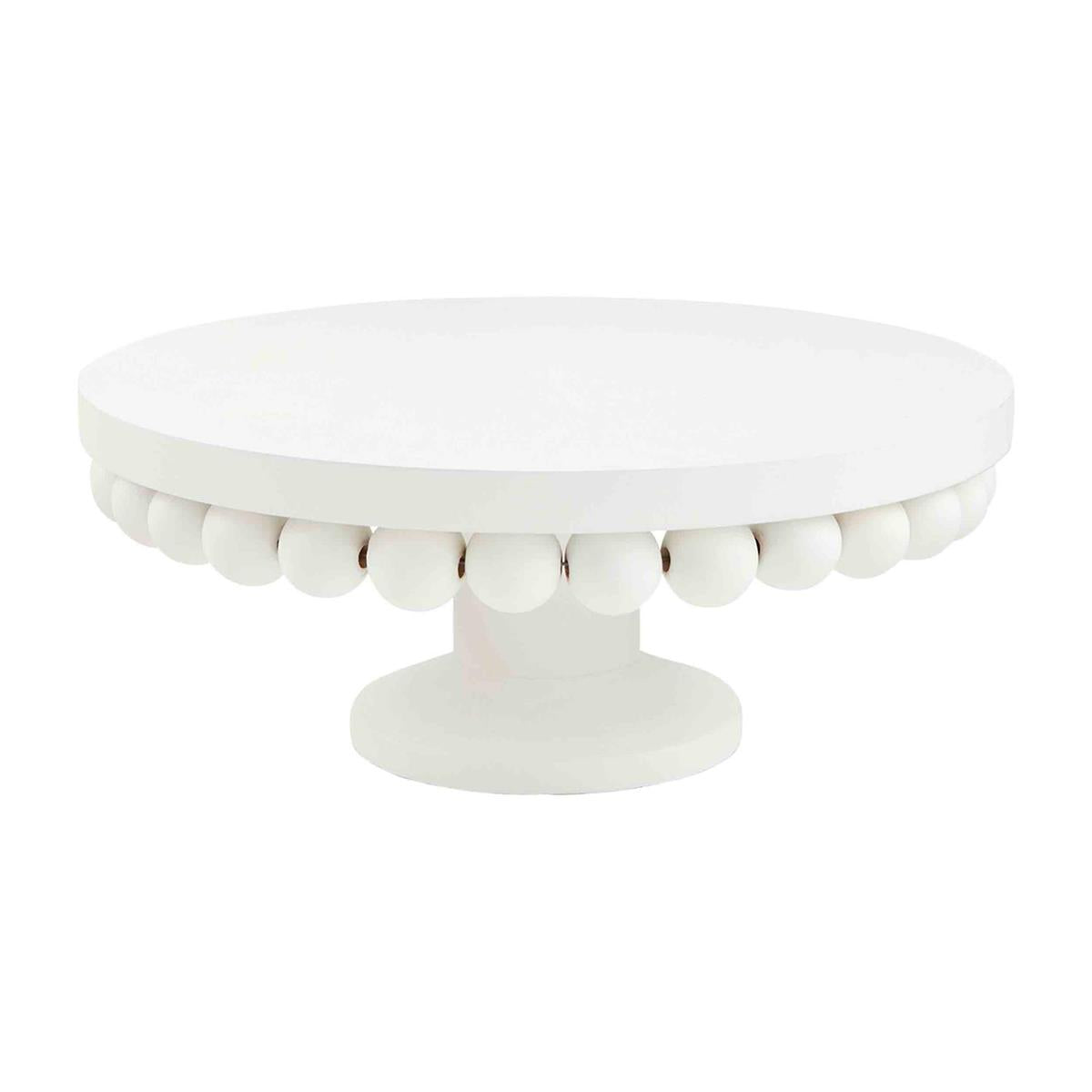 White round cake stand isolated on a white background featuring a smooth top surface and a distinctive scalloped edge of small white spheres above a sturdy pedestal base