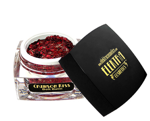 Product shot of Elektra Cosmetics Crimson Kiss Bolt Balm in an open clear jar filled with vibrant chunky red and gold glitter, beside a black lid featuring the bold gold Elektra Cosmetics logo