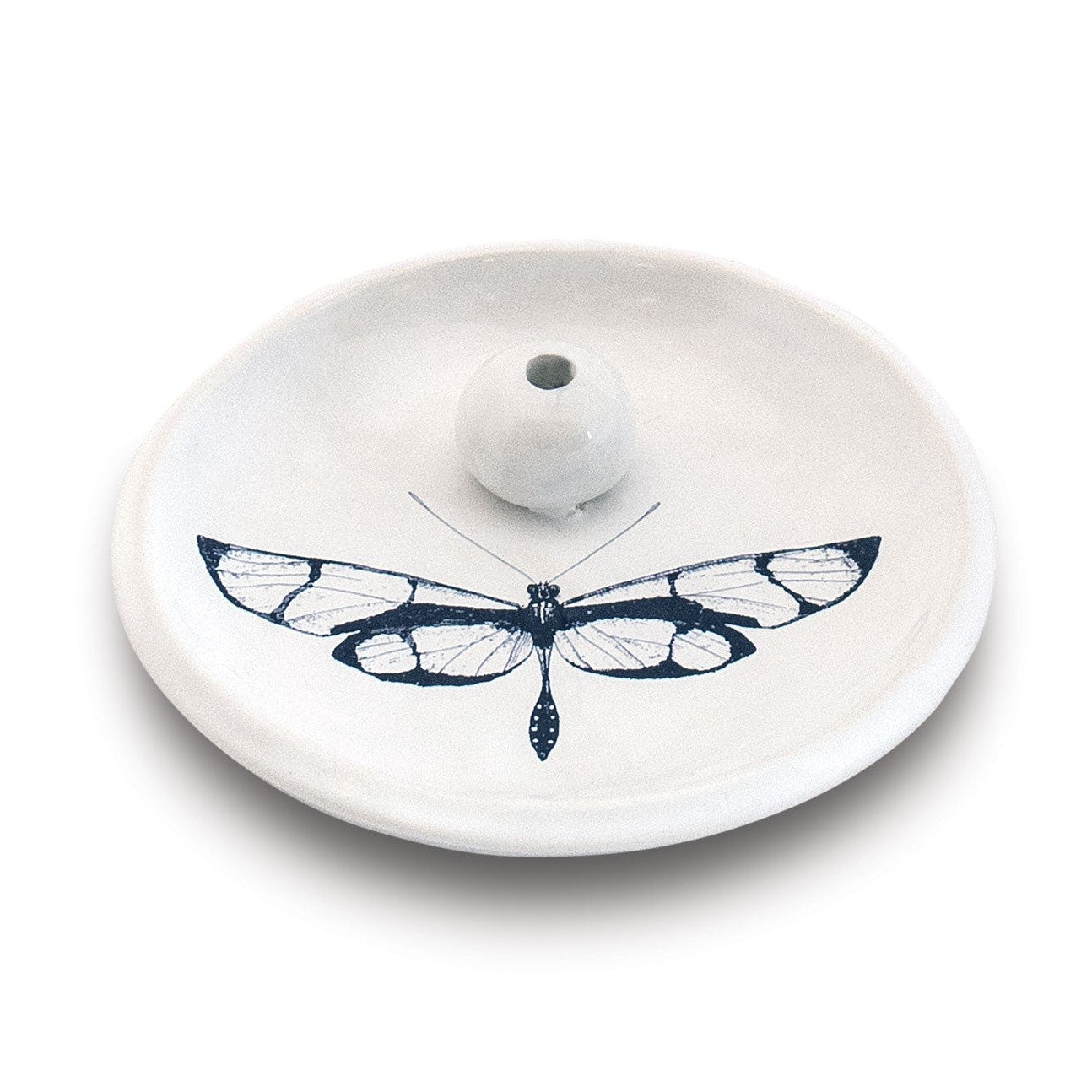 White ceramic incense holder featuring a stylized blue and white dragonfly with translucent wing patterns a dotted tail and a central spherical stick holder