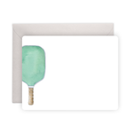Watercolor illustration of a mint green pickleball paddle with a textured brown handle on a blank white note card presented with a light gray envelope