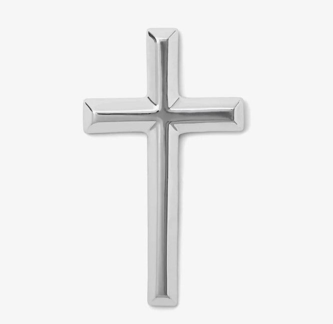 Photograph of a shiny polished silver Latin cross featuring prominent reflective beveled edges on a simple white backdrop