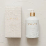 Product photography of a white L'AVANT COLLECTIVE natural dish soap bottle with gold accents and a matching crocodile-textured box on a clean white background, highlighting an embossed wave pattern on the bottle's base