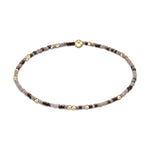 Beaded bracelet featuring a mix of small brown and grey beads with interspersed gold beads and a central larger gold bead