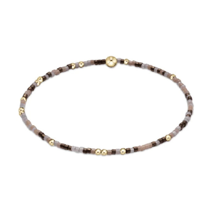 Beaded bracelet featuring a mix of small brown and grey beads with interspersed gold beads and a central larger gold bead