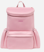 Product photo of a CORKCICLE light pink backpack featuring a rounded top flap closure, the magenta CORKCICLE logo, a front pocket, and gathered expandable sides