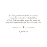 Bible verse graphic featuring the scripture 1 John 3:1 in gray font on a white background, highlighted by a small red heart dividing line