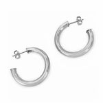 Pair of polished silver chunky hoop earrings with post-back closures on a white background