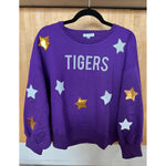 Mary Square purple sweatshirt hanging on a black hanger against a light wood panel wall features TIGERS in silver glitter text and is embellished with scattered gold and silver sequin stars