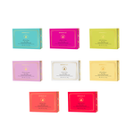 Product photography of Spongellé body buffers displayed in eight vibrant colored boxes including turquoise, fuchsia, and lime green, each labeled 30+ uses