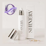 Photograph of SHINERY Radiance Wash bottle and box on a white surface, featuring a silver pump top, a metallic silver cap, two gold rings with sparkling clear stones, and an Oprah's Favorite Things 2023 purple wreath badge