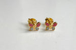 Pair of gold-toned butterfly stud earrings featuring bright pink enamel upper wings and light gray enamel lower wings resting on a clean white surface