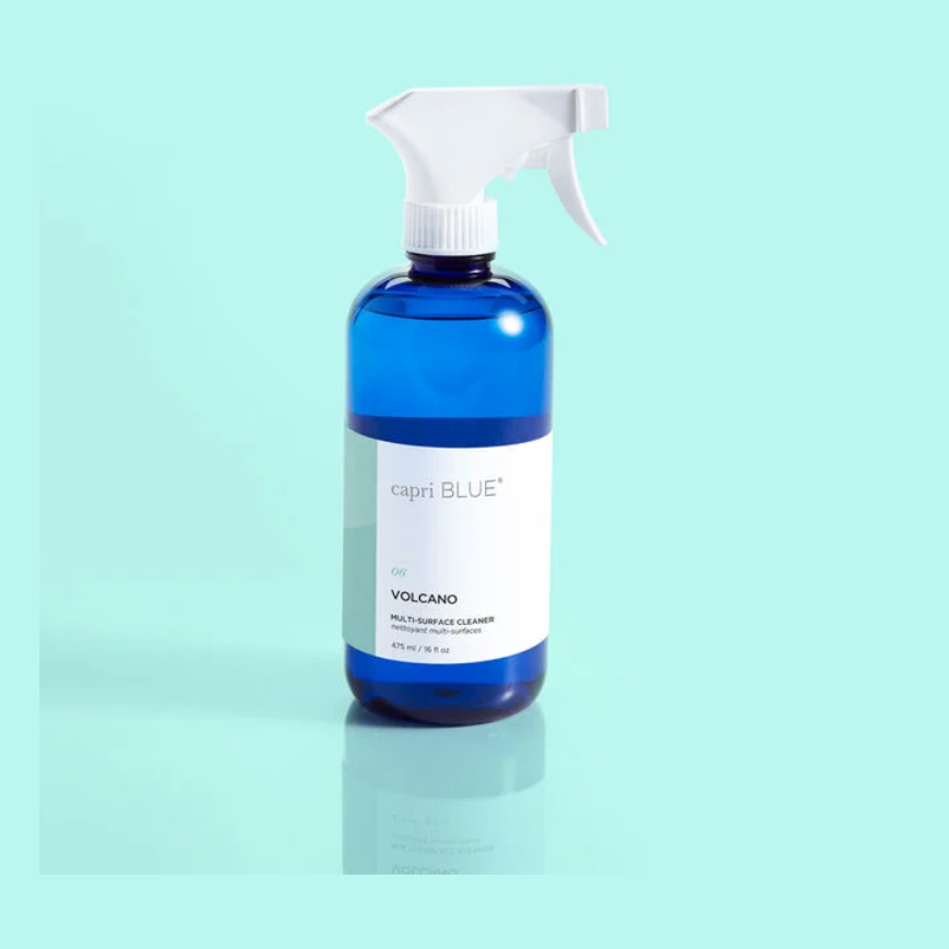 blue bottle of capri blue volcano scented multi-surface cleaner on a light blue background