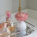 white flower diffuser on a bathroom counter. Sitting in a decorative tray